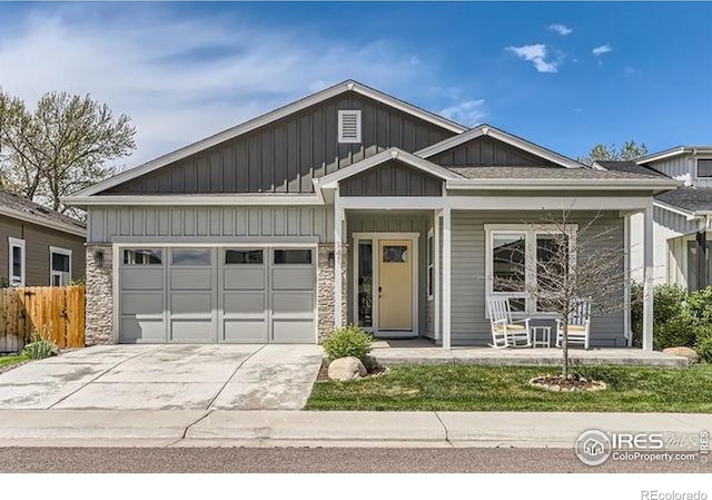 view of front of home featuring a garage, fence, concrete driveway, board and batten siding, and a porch