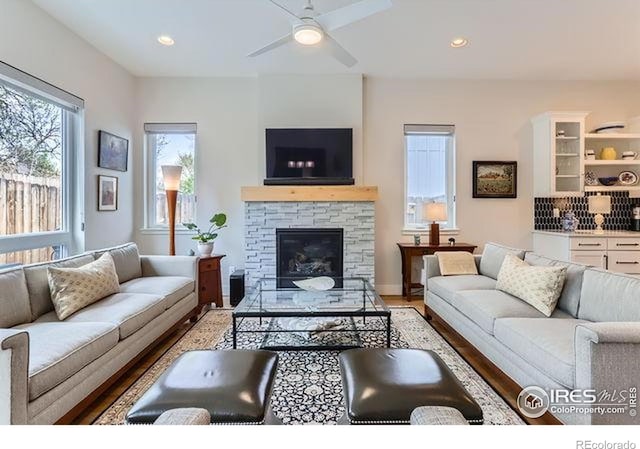 living area with a fireplace, ceiling fan, light wood-style flooring, and recessed lighting