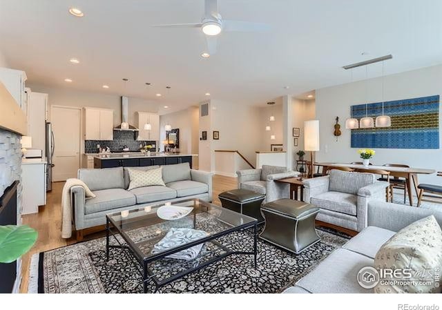 living area with light wood-style floors, visible vents, ceiling fan, and recessed lighting