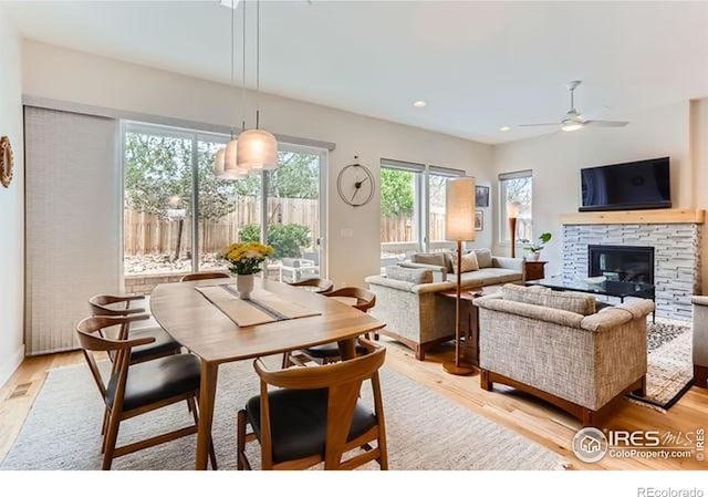 dining room with recessed lighting, light wood finished floors, a fireplace, and ceiling fan