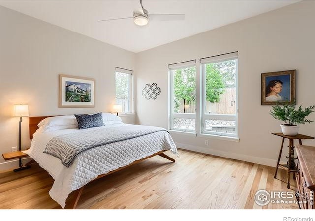 bedroom featuring light wood finished floors, baseboards, and a ceiling fan