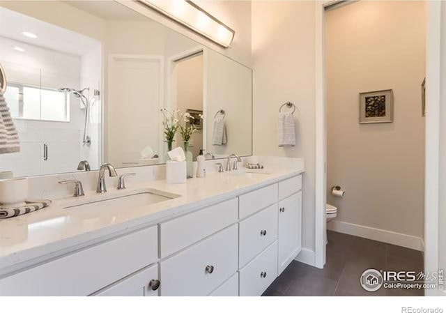full bath featuring a sink, double vanity, toilet, and tile patterned floors