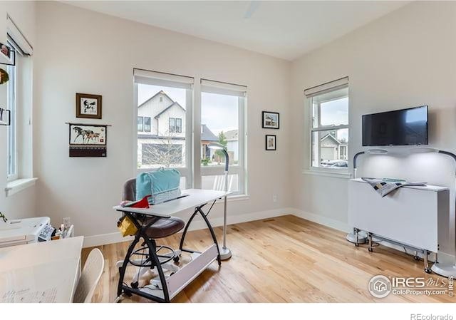 office space with baseboards and light wood-style floors