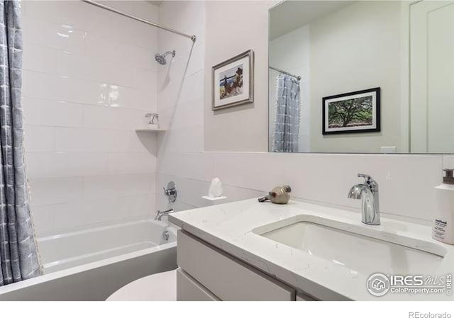 bathroom featuring shower / bath combo with shower curtain, toilet, and vanity
