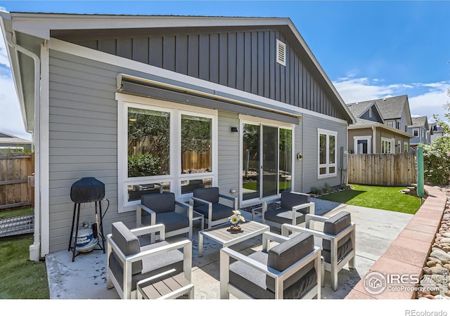 rear view of house featuring fence, a patio, outdoor lounge area, and board and batten siding