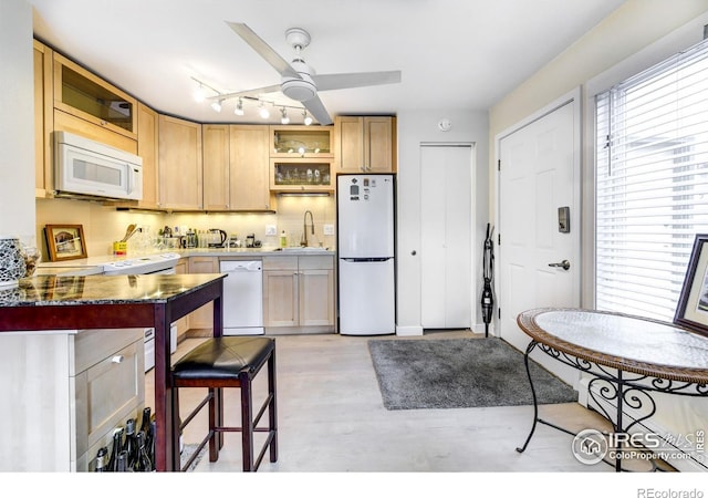 kitchen with a sink, open shelves, white appliances, and light wood-style floors