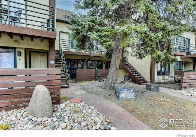 property entrance with stucco siding and fence