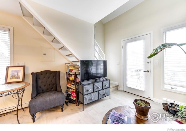 living area featuring stairway, electric panel, and wood finished floors