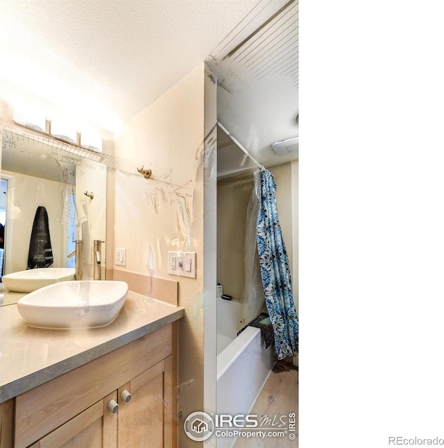 full bath with shower / bath combo with shower curtain and vanity