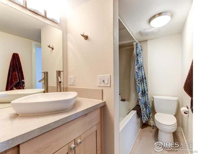 full bathroom featuring toilet, shower / tub combo with curtain, and vanity