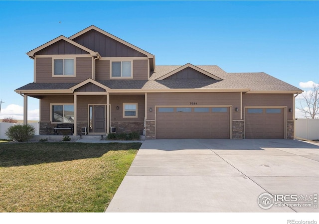 7084 Sumner St, Wellington, CO 80549 - craftsman inspired home with driveway, board and batten siding, a front yard, a garage, and stone siding