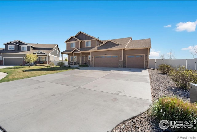7084 Sumner St, Wellington, CO 80549 - craftsman-style house featuring concrete driveway, stone siding, a garage, and fence
