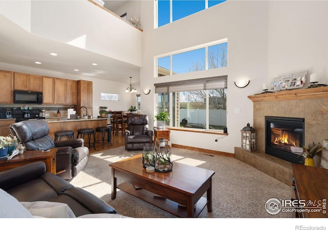 7084 Sumner St, Wellington, CO 80549 - living area with light colored carpet, recessed lighting, a fireplace, a high ceiling, and baseboards