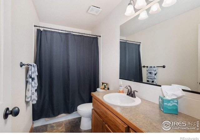 7084 Sumner St, Wellington, CO 80549 - full bathroom with toilet, vanity, visible vents, backsplash, and stone finish flooring