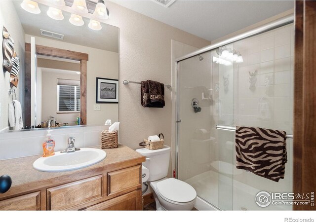 7084 Sumner St, Wellington, CO 80549 - full bathroom with toilet, visible vents, a shower stall, a textured wall, and vanity