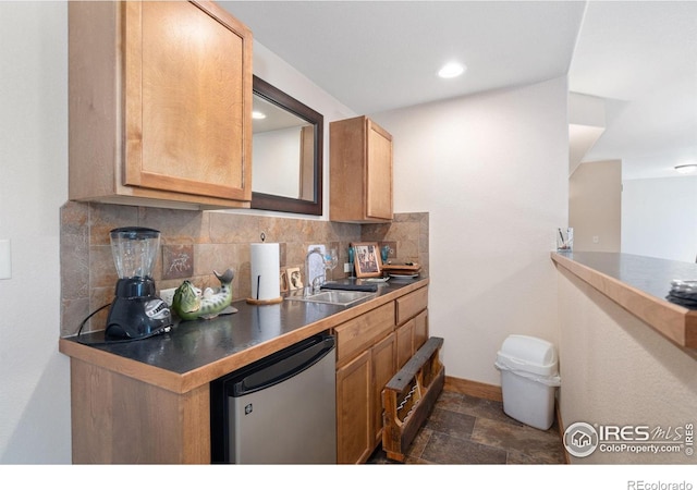 7084 Sumner St, Wellington, CO 80549 - kitchen featuring a sink, tasteful backsplash, dishwashing machine, stone finish flooring, and baseboards