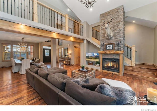14582 Homestead Pl, Broomfield, CO 80023 - living area with a chandelier, high vaulted ceiling, wood-type flooring, a stone fireplace, and recessed lighting