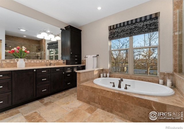 14582 Homestead Pl, Broomfield, CO 80023 - bathroom featuring a bath, vanity, stone tile flooring, and recessed lighting