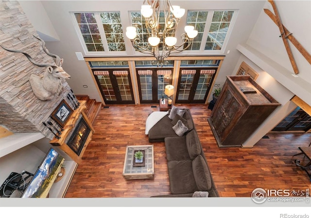 14582 Homestead Pl, Broomfield, CO 80023 - living room with french doors, wood finished floors, a towering ceiling, and a chandelier