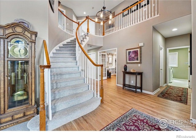 10305 Charissglen Cir, Highlands Ranch, CO 80126 - stairs with wood finished floors, a high ceiling, a chandelier, and recessed lighting