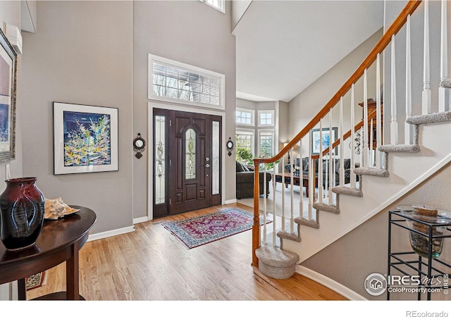10305 Charissglen Cir, Highlands Ranch, CO 80126 - entryway with wood finished floors, a high ceiling, and stairs
