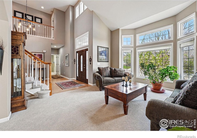 10305 Charissglen Cir, Highlands Ranch, CO 80126 - living room featuring carpet floors, plenty of natural light, a towering ceiling, and a chandelier