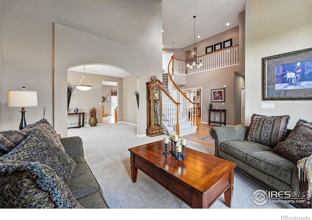 10305 Charissglen Cir, Highlands Ranch, CO 80126 - carpeted living area with arched walkways, a towering ceiling, stairs, and recessed lighting