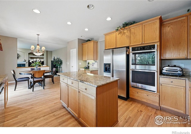 10305 Charissglen Cir, Highlands Ranch, CO 80126 - kitchen with appliances with stainless steel finishes, a kitchen island, light wood-type flooring, recessed lighting, and a chandelier