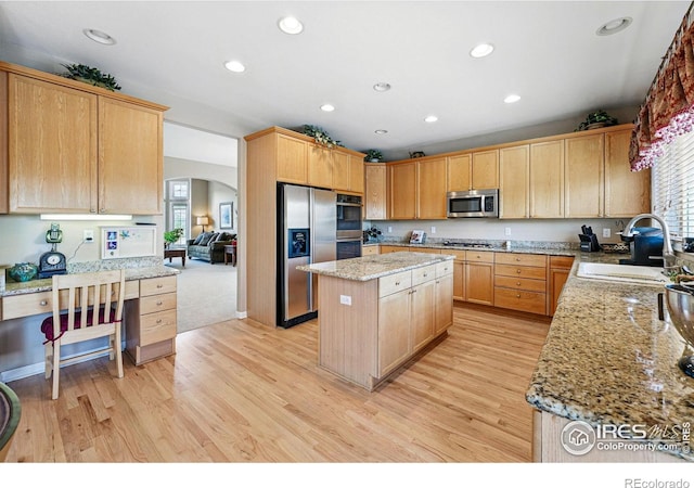 10305 Charissglen Cir, Highlands Ranch, CO 80126 - kitchen featuring stainless steel appliances, arched walkways, light wood finished floors, a center island, and healthy amount of natural light
