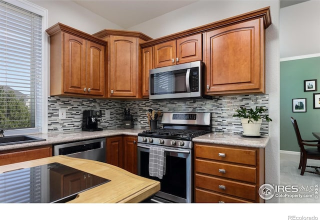 1809 Keel Ct, Lafayette, CO 80026 - kitchen with baseboards, brown cabinets, tasteful backsplash, and appliances with stainless steel finishes