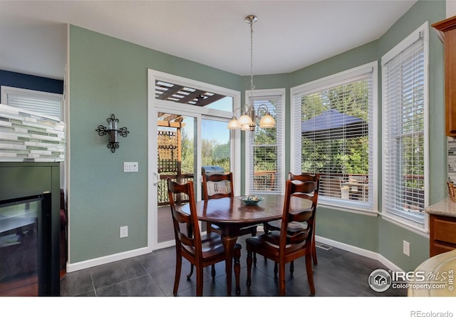 1809 Keel Ct, Lafayette, CO 80026 - dining room featuring an inviting chandelier, dark tile patterned floors, and baseboards