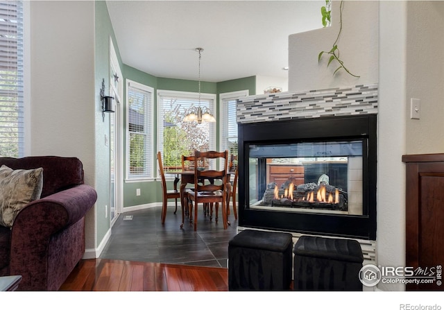 1809 Keel Ct, Lafayette, CO 80026 - interior space featuring baseboards, dark wood-style flooring, a tiled fireplace, and a chandelier