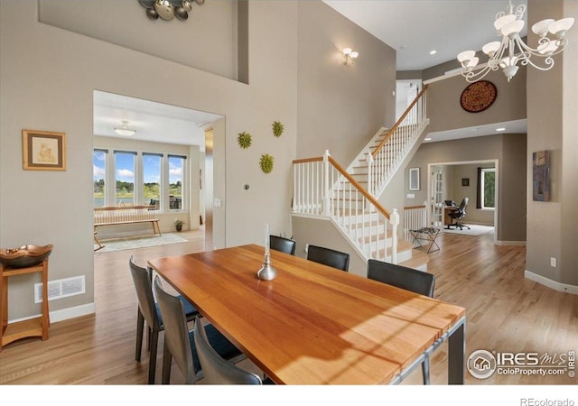 dining room with baseboards, stairs, a high ceiling, and wood finished floors