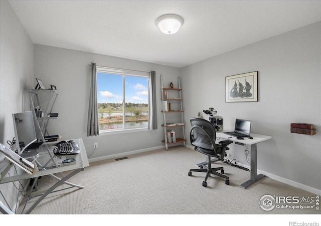carpeted office with visible vents and baseboards