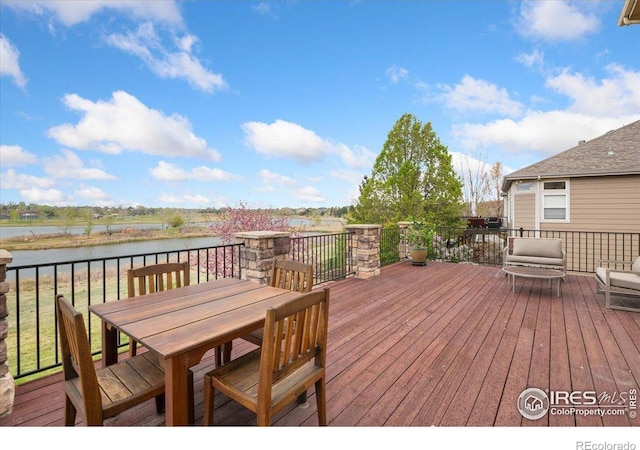 deck featuring a water view and outdoor dining area