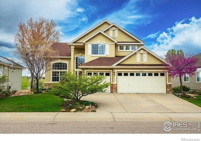 view of front of property with stone siding, stucco siding, driveway, and a front lawn
