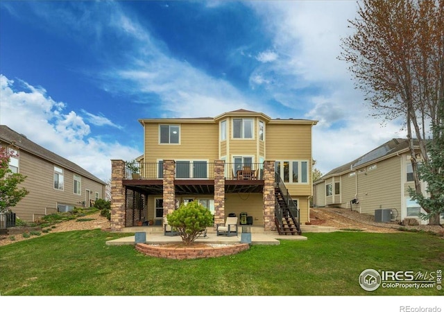 rear view of property featuring a yard, stairs, a patio, and a wooden deck