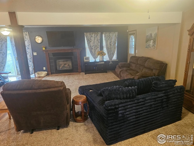 carpeted living room featuring a tiled fireplace and plenty of natural light