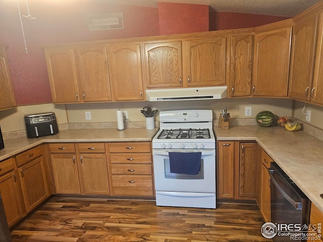 kitchen featuring white gas range oven, stainless steel dishwasher, dark wood-style floors, and extractor fan