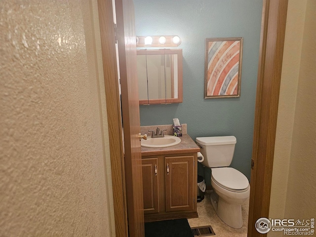 bathroom with toilet, visible vents, and vanity