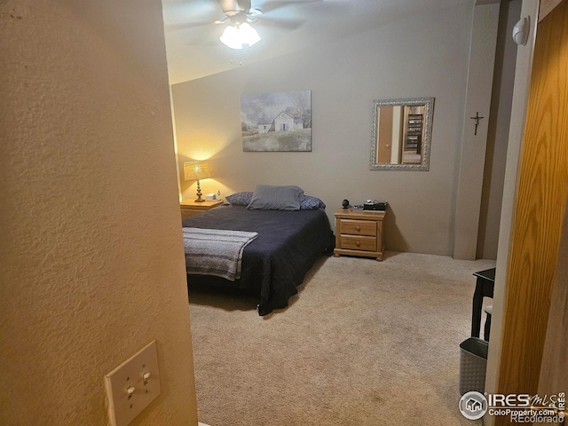 carpeted bedroom with ceiling fan, lofted ceiling, and a textured wall