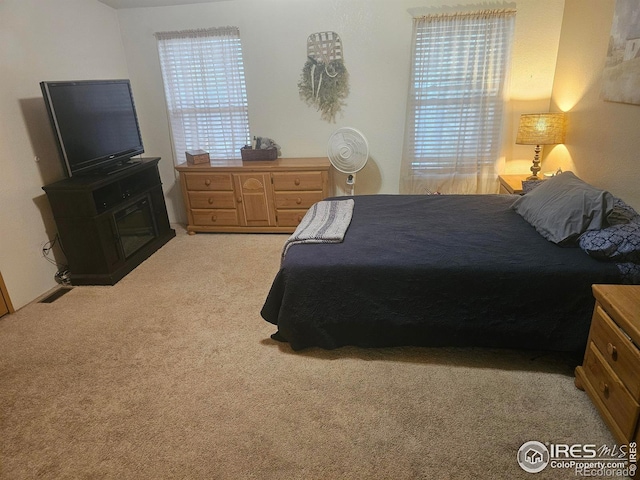 carpeted bedroom featuring visible vents