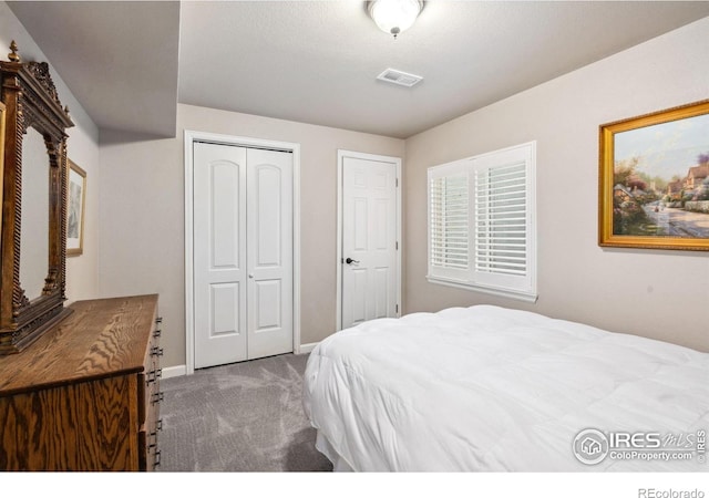 carpeted bedroom with a closet, visible vents, and baseboards