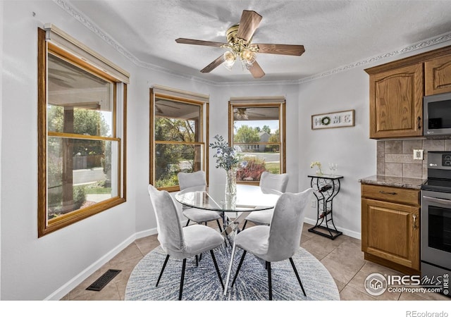 dining room featuring light tile patterned floors, a textured ceiling, visible vents, baseboards, and ceiling fan