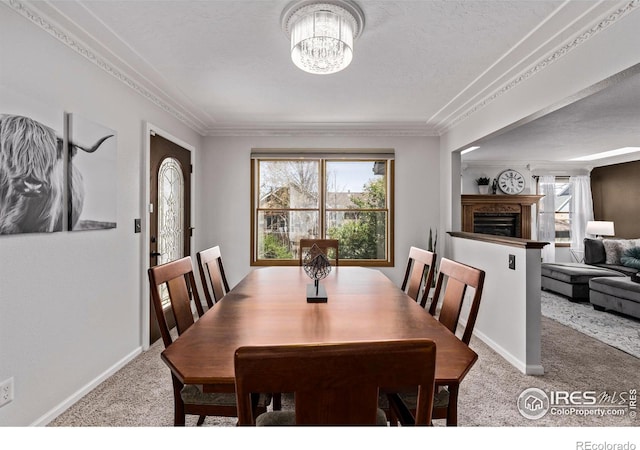 dining room with ornamental molding, plenty of natural light, a chandelier, and carpet