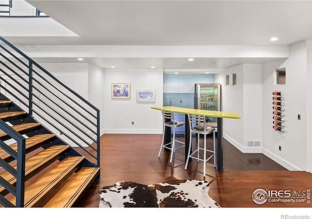 7230 Spanish Bay Dr, Windsor, CO 80550 - dining space featuring wood finished floors, baseboards, stairs, recessed lighting, and a bar