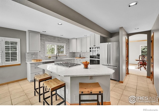 2206 Eagles Nest Dr, Lafayette, CO 80026 - kitchen featuring a sink, a center island, light tile patterned floors, and appliances with stainless steel finishes