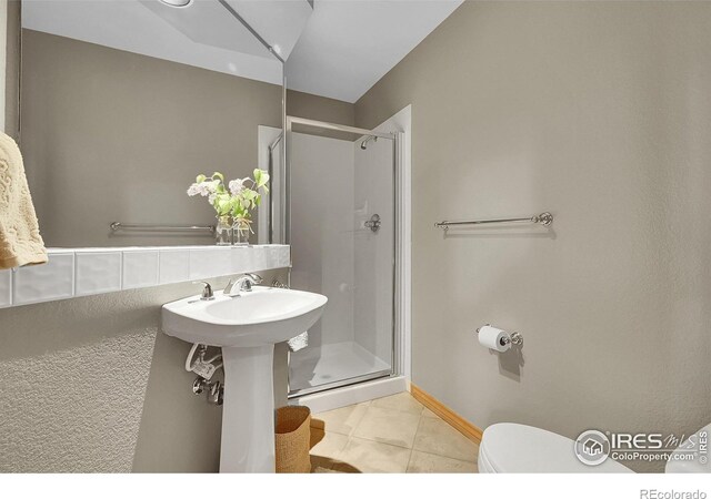2206 Eagles Nest Dr, Lafayette, CO 80026 - full bathroom featuring tile patterned flooring, toilet, baseboards, and a shower stall