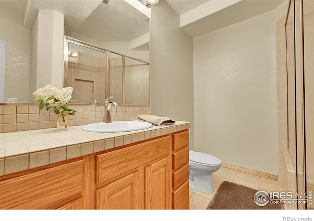2206 Eagles Nest Dr, Lafayette, CO 80026 - bathroom featuring toilet, tile patterned flooring, vanity, an enclosed shower, and tasteful backsplash