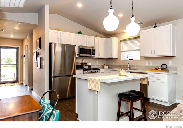 506 Bobcat Ct, Wiggins, CO 80654 - kitchen with appliances with stainless steel finishes, dark wood-style floors, lofted ceiling, white cabinets, and recessed lighting